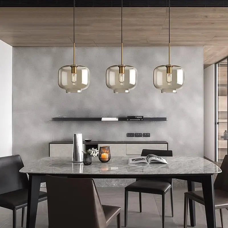 Modern smoked glass pendant lights with brass accents for kitchen island